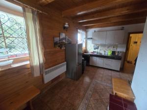 a kitchen with a refrigerator and a window at Chata Hrabovo in Ružomberok
