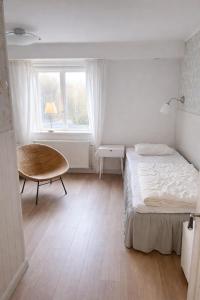 a bedroom with a bed and a chair and a window at Apartment in central Båstad in Båstad