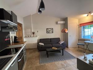 a living room with a couch and a kitchen at Escapade entre Mer et Montagnes in Saint-Martin-du-Var