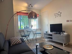 a living room with a couch and a flat screen tv at Escapade entre Mer et Montagnes in Saint-Martin-du-Var