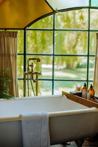 a bath tub in a room with a large window at Don Aniceto Lodges & Glamping in Luján +69 photos