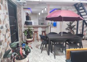 a black table with chairs and an umbrella in a room at Habitaciones de alquiler in La Libertad