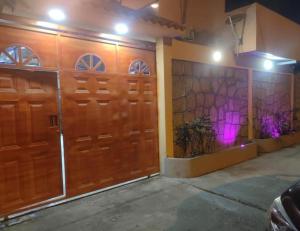 a garage with two wooden doors and purple lights at Habitaciones de alquiler in La Libertad