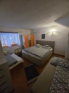 a bedroom with two beds and two windows at Chata Hrabovo in Ružomberok