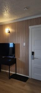 a room with a door and a table with a lamp at Centennial Motel in Kindersley