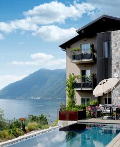 a building with a swimming pool next to the water at Villa Clementina Boutique Hotel in Colonno