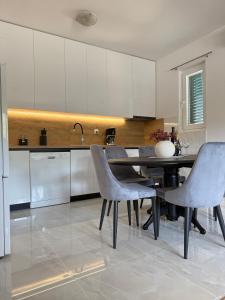 a kitchen with a dining room table and chairs at Mediterranean Olive WaterfallsKRKA-Croatia in Gulin