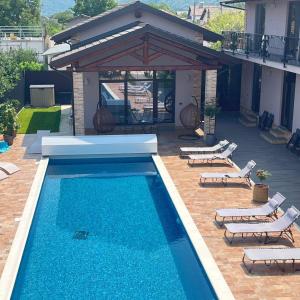 a swimming pool with lounge chairs and a pavilion at Ale&Sere Housing in Jiblea Nouă