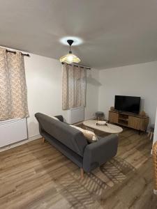a living room with a couch and a tv at Panach in Saint-Loubès