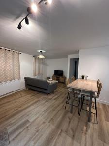 a living room with a couch and a table at Panach in Saint-Loubès