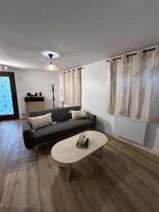 a living room with a black couch and a table at Panach in Saint-Loubès