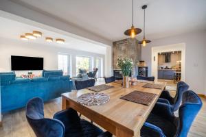 a living room with a wooden table and blue chairs at Widokówka 13 in Mikołajki +169 photos