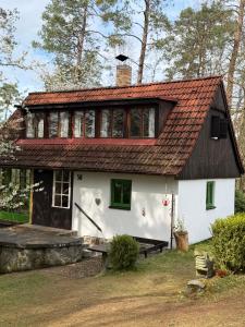 a white house with a red roof at Chata nad řekou Otavou in Vojníkov