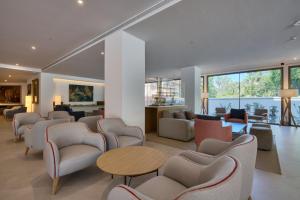 a lobby with chairs and tables and a living room at Hotel Ybarra Sevilla in Seville
