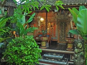 a house with a porch with plants in front of it at Angga Homestay in Ubud