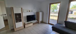 a living room with a tv and a couch at Spessartblick Eisingen in Eisingen