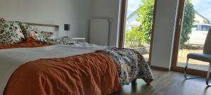 a bedroom with a bed with an orange blanket and a window at Spessartblick Eisingen in Eisingen