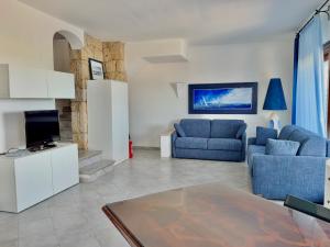 a living room with two blue couches and a tv at Villa Azzurra in Cannigione