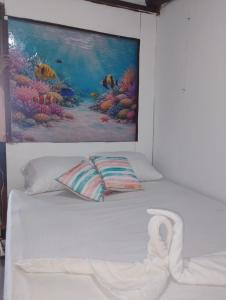 a white bed with a painting on the wall at Pikua Beach Baru in Playa Blanca