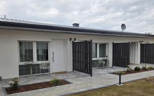 a white house with black gates and a patio at Regenbogen8 Ferienwohnungen in Linsengericht