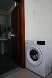 a white washing machine in a bathroom with a sink at Gees House in Golem