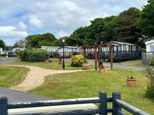 a park with a pavilion and houses in the background at 820 Ocean View, Lydstep Haven Beach in Tenby