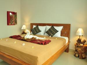 Un dormitorio con una cama grande con un cisne. en Angga Homestay, en Ubud