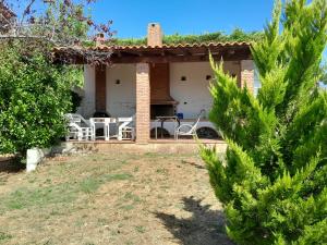 a house with a table and chairs in a yard at Mulberry Tree in Agia Anna