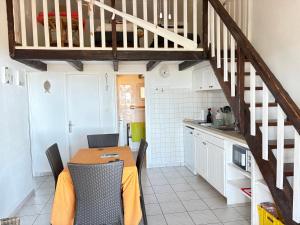 a kitchen with a table with chairs and a staircase at auxcheneslieges in Lecci