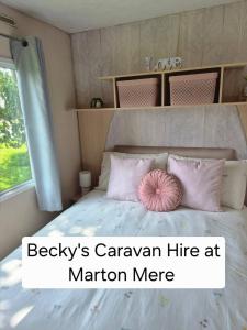 a bedroom with a bed with a pink pillow on it at Becky's Caravan at Marton Mere in Blackpool