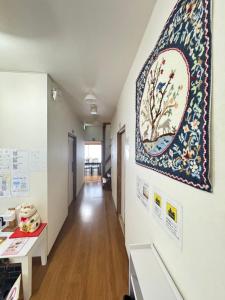 a hallway with a tapestry hanging on a wall at Waraku No2,Guesthouse near KIX in Izumi-Sano