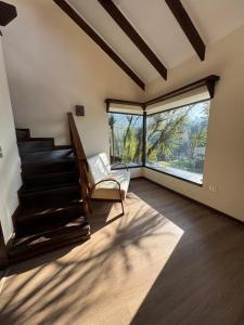 a living room with a staircase and a chair at Cabañas del Puerto in Puerto Montt