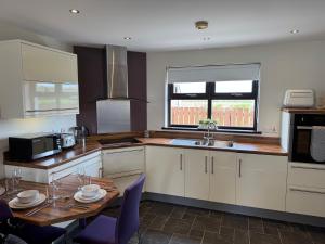 a kitchen with a table and a sink and a stove at Marions Place in Finvoy