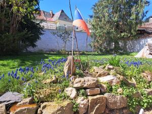 an umbrella in a garden with blue flowers and rocks at Pension Garage in Kutná Hora