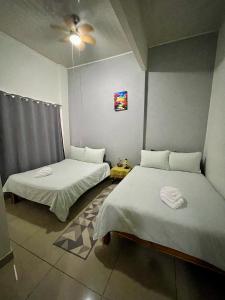 a bedroom with two beds and a ceiling fan at Heliconia Suite 5min to Waterfall - Shared Pool Pool in Fortuna +31 photos