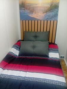 a bedroom with a bed with a poster on the wall at Domek modułowyBursztynek in Rewa
