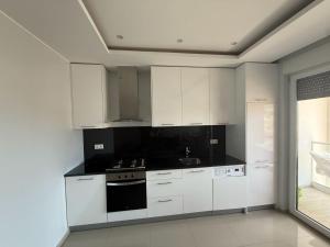a kitchen with white cabinets and a stove top oven at Miles Dreams Laginha in Mindelo