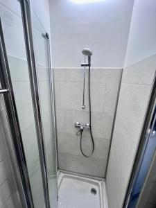 a shower with a hose in a shower stall at Mini-studio de 15m2 à 8 min de Paris in Maisons-Alfort +5 photos
