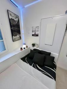 a white room with a couch and some pictures at Mini-studio de 15m2 à 8 min de Paris in Maisons-Alfort