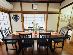 a dining room with a black table and chairs at Waraku No2,Guesthouse near KIX in Izumi-Sano +47 photos