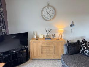 a living room with a clock on the wall at Marions Place in Finvoy