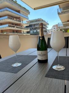 a bottle of wine and two glasses on a table at Domus Leonardo Apartment in Fiumicino Airport