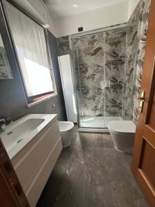 a bathroom with a shower and a toilet and a sink at Domus Leonardo Apartment in Fiumicino Airport +28 photos