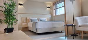 a bedroom with a bed and a plant and a chair at Anémona Apartments in Matosinhos