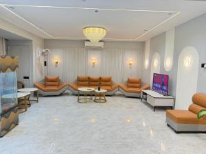 a living room with couches and tables and a tv at Hotel The Galaxy in Dabok