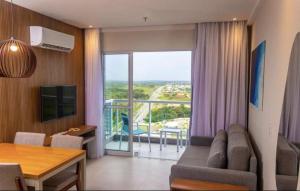 a living room with a couch and a table and a balcony at Aqualand resorts 1Q in Salinópolis