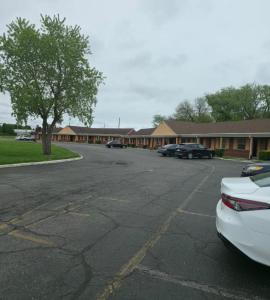 a parking lot with cars parked in front of a building at Dover Inn in Dover