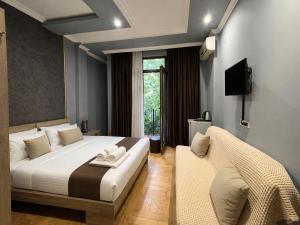a bedroom with a bed and a tv and a couch at Hotel Elite in Batumi