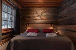 a bedroom with a bed in a log cabin at Villa Poronperä in Kuusamo