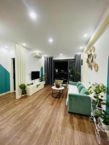 a living room with a blue couch and a tv at The Timegarden Homestay in Ha Long